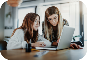 To unge kvinner studerer PC-skjermen.
