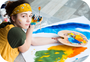 Ung kvinne med fargerike klær og palett, maler med akryl.